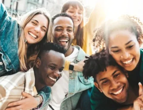 A group of six smiling, multiracial teenagers