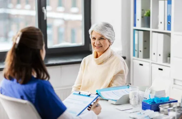 A Medicare Representative speaking to a happy elderly woman