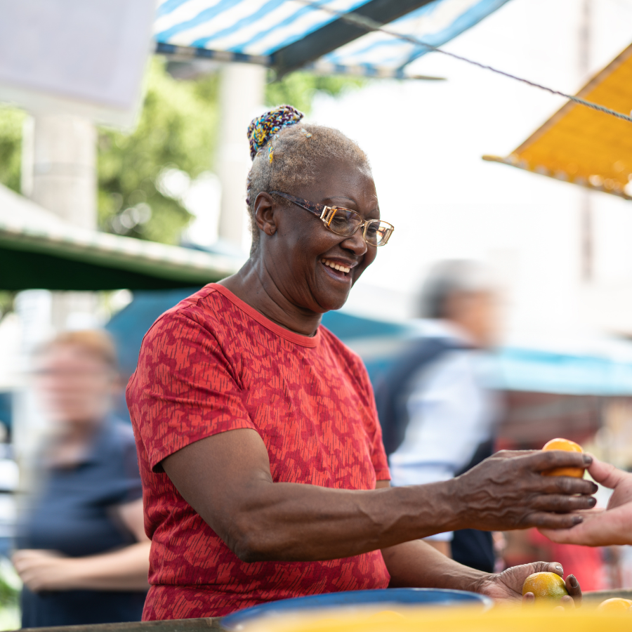 image of woman holding fruit in farmer's market